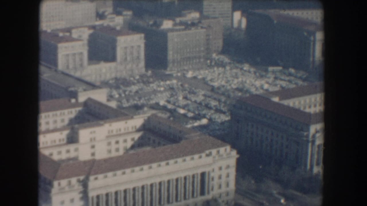Aerial view of classical buildings, parking lots, and city blocks in hazy light.