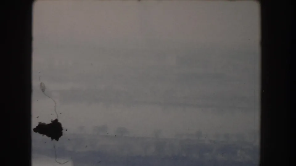 1960 8mm frame showing a soft, gray sky before the camera settles on the Washington, DC building exterior.