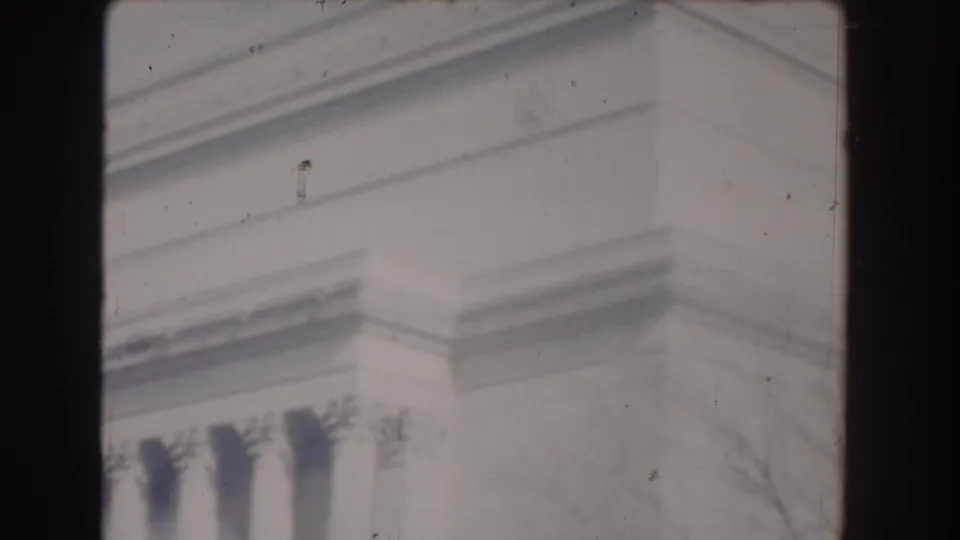 1960 Washington, DC home-movie frame showing close stone architectural detail, likely from the Lincoln Memorial, with visible film wear.