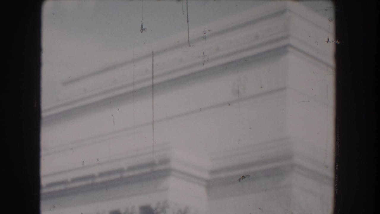 Soft 8mm frame from Washington, DC showing pale stone monument detail with scratches and gate-edge borders.