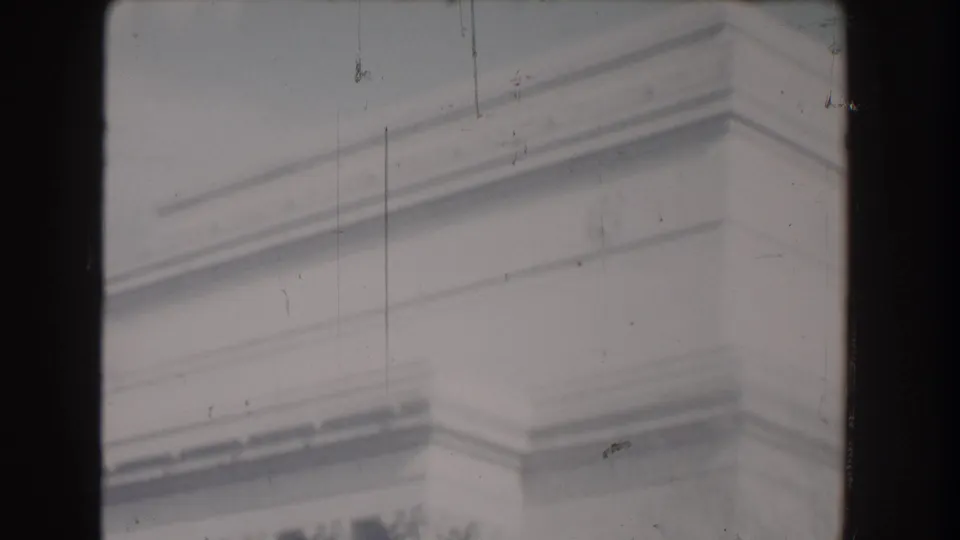 Soft 8mm frame from Washington, DC showing pale stone monument detail with scratches and gate-edge borders.
