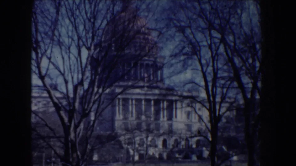 1960 Washington, DC home-movie view of the U.S. Capitol dome and facade framed by leafless trees.