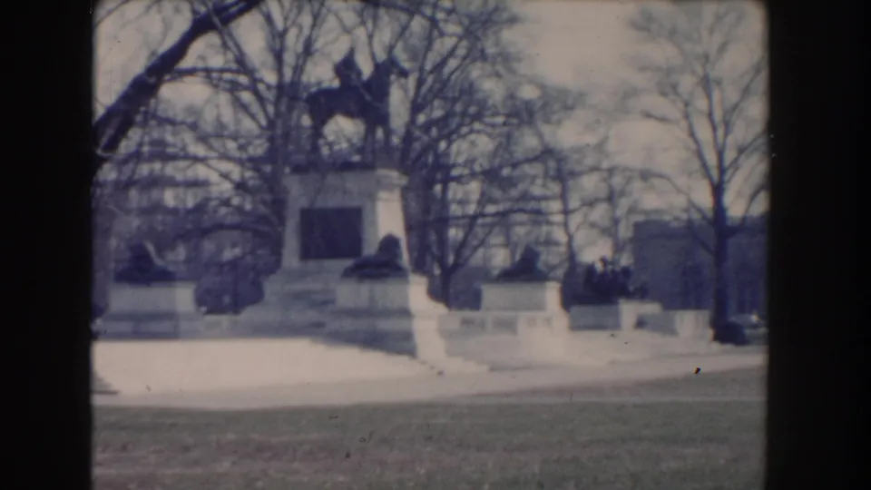 1960 Washington, DC home-movie view of an equestrian monument on a stone base among winter trees.