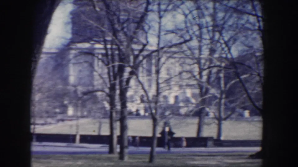 Washington, DC park view from 1960 showing bare trees, lawn, road, and a pale distant monument or civic building detail.