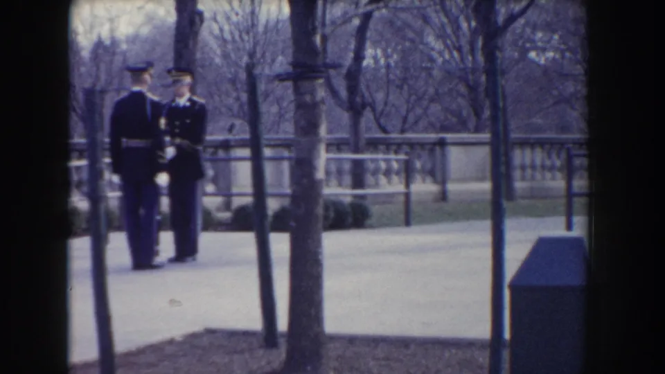 The final 1960 Washington, DC frame keeps two uniformed soldiers with rifles centered on a paved park walkway.
