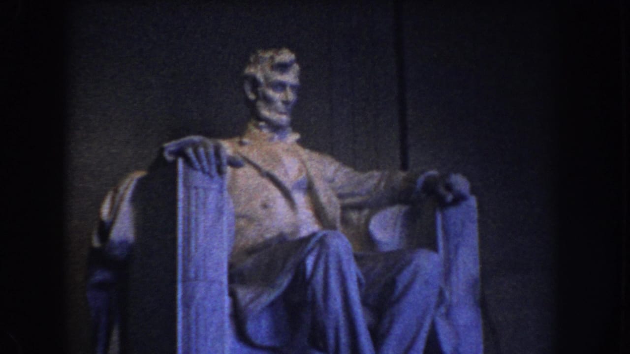 Seated Lincoln statue inside the Lincoln Memorial, framed in dim blue-toned light.