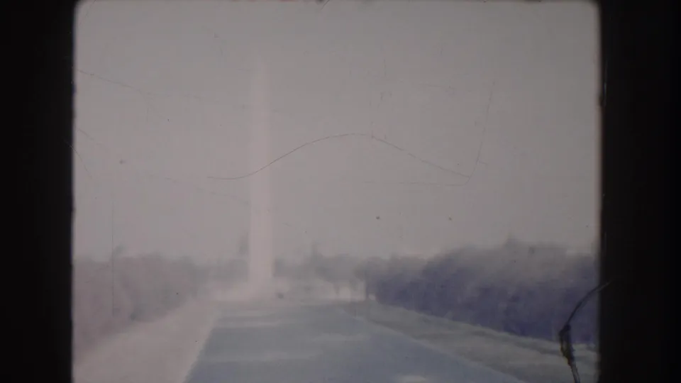 1960 Washington DC 8mm frame showing a soft, hazy distant view across a broad path or roadway near the National Mall.