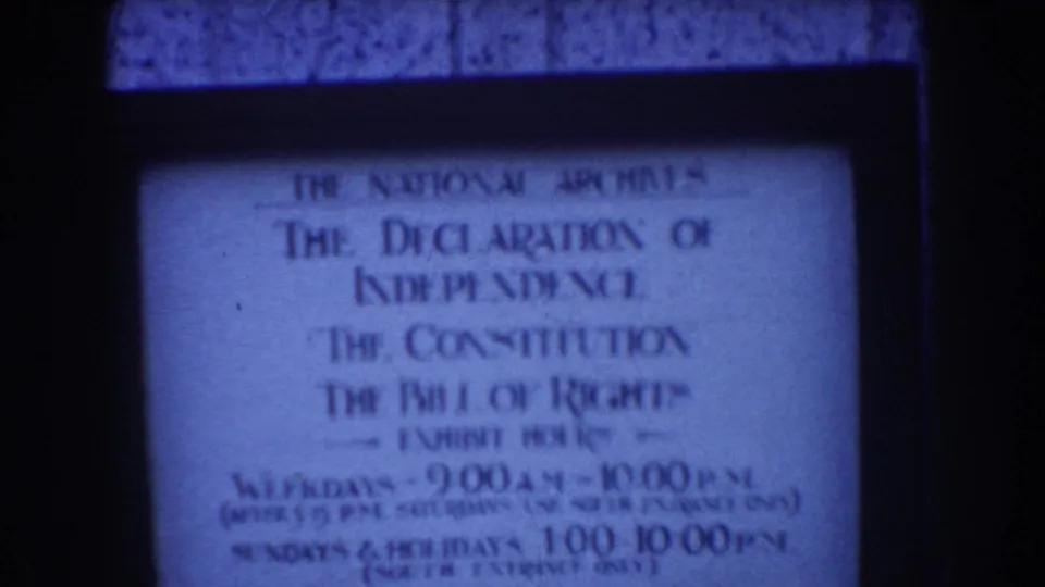 Washington DC home-movie frame with a National Archives sign naming the Declaration of Independence, Constitution, and Bill of Rights.