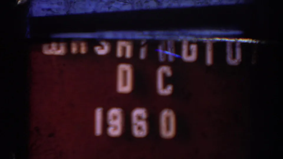 8mm travel title card reading Washington DC 1960, with raised white lettering on a dark red-brown board and visible film wear.