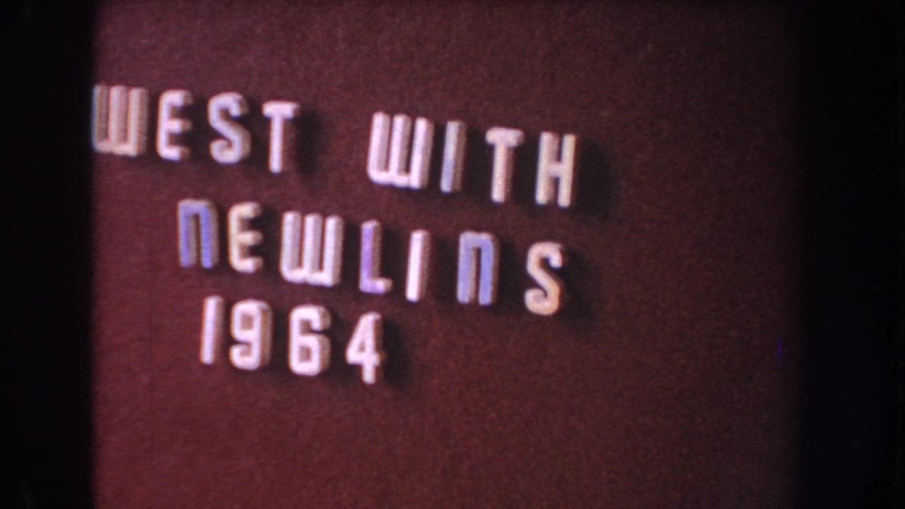 8mm frame showing a dark title card with raised white letters reading "WEST WITH NEWLINS 1964," with soft focus and film grain.