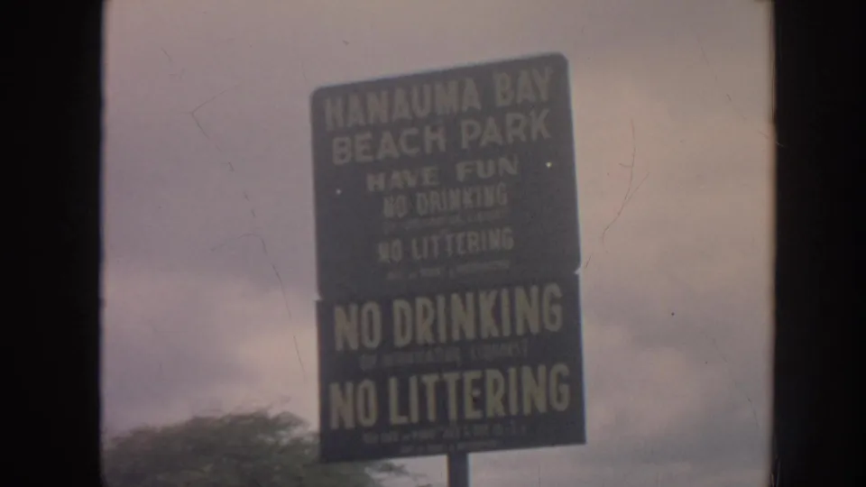 Readable Hanauma Bay Beach Park sign with no drinking and no littering warnings, filmed in Hawaii in 1961.