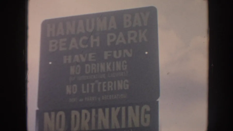 Close 8mm frame of the Hanauma Bay Beach Park sign reading have fun, no drinking, and no littering.