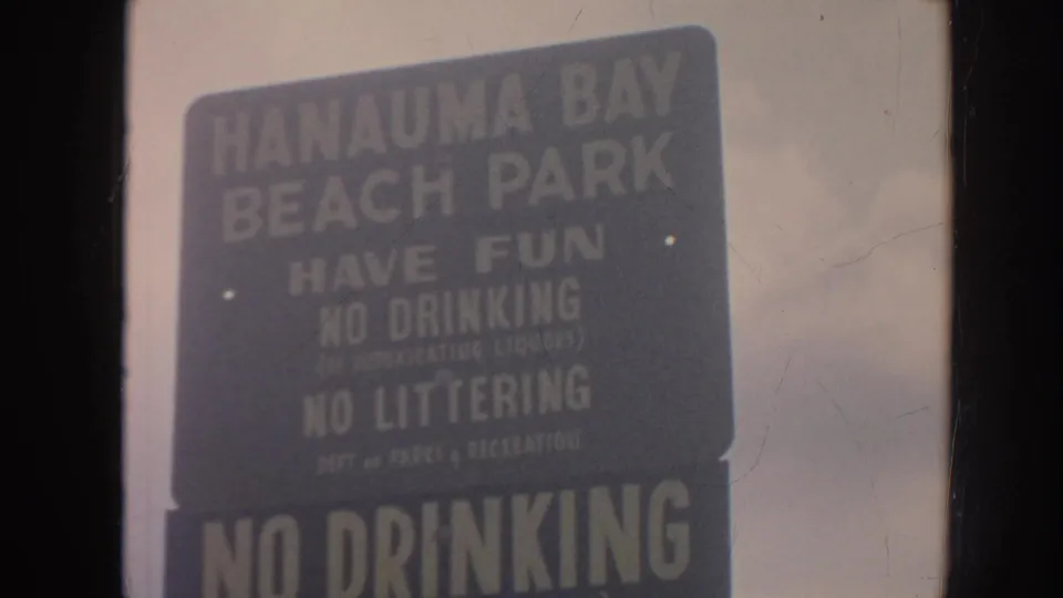 Hanauma Bay Beach Park rules sign fills the frame, with faded 8mm color and visible surface wear.