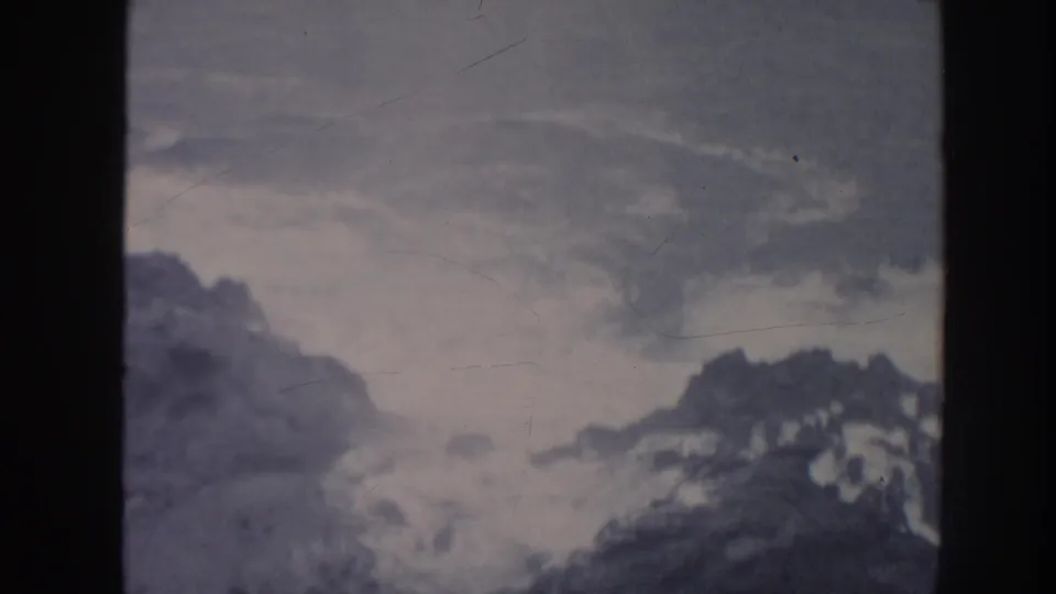 1961 Hawaii 8mm frame showing overcast sky and distant mountain forms viewed through dark vertical framing.