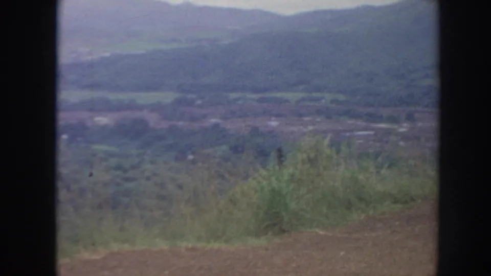 1961 Hawaii 8mm frame of a lush valley and distant ridges, seen through a soft, grainy home-movie scan.