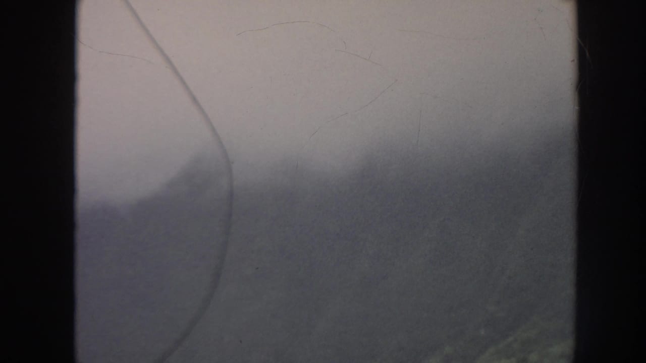 Fog-covered Hawaiian mountain ridge in soft 8mm color footage from the 1961 home-movie clip.