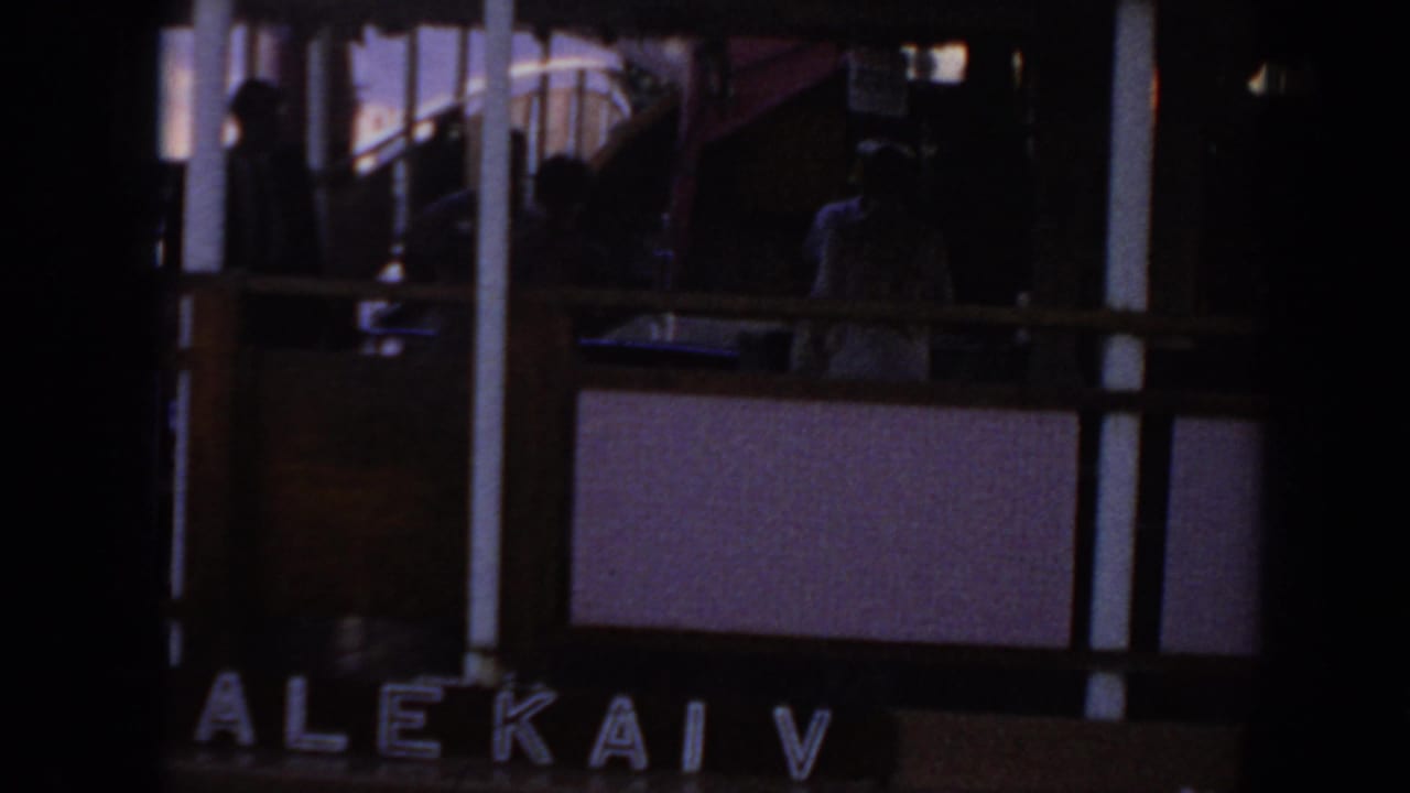 1961 Hawaii frame showing the side of a vessel marked ALEKAI V, with people visible in shadow on the upper deck.