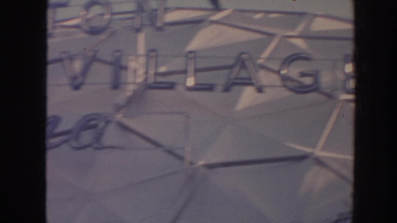 Close 1961 Hawaii home-movie view of Hilton Hawaiian Village lettering on a geometric resort sign.