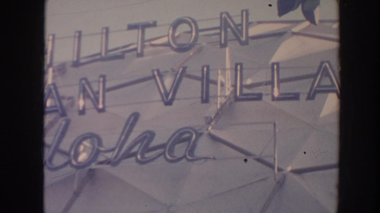 Hilton Hawaiian Village sign in Hawaii, with aloha script and mid-century geometric wall detail visible.