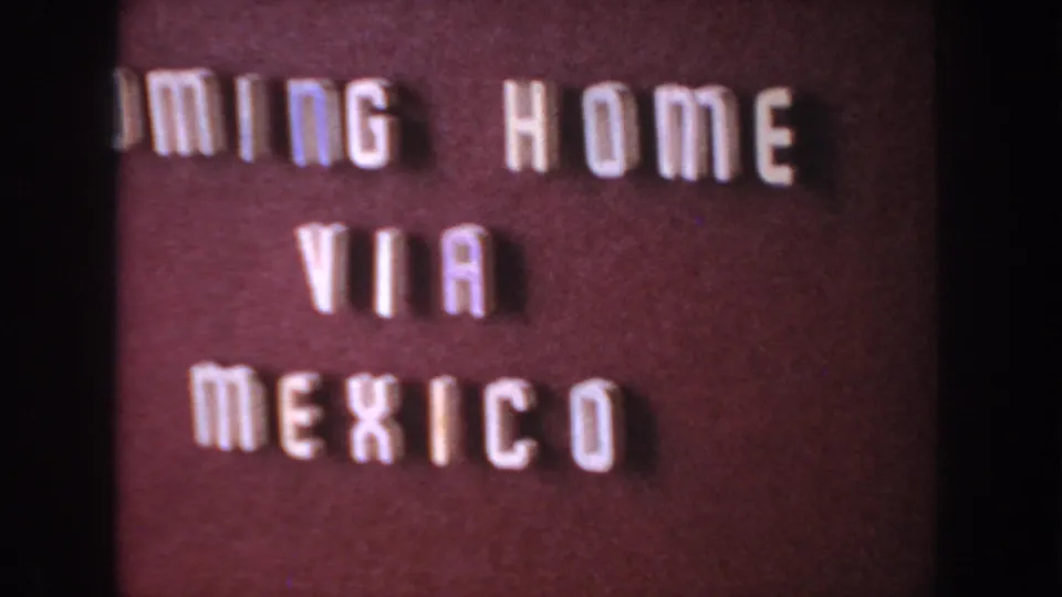 Cropped 8mm frame of the COMING HOME VIA MEXICO title card, showing white letters against a maroon background.