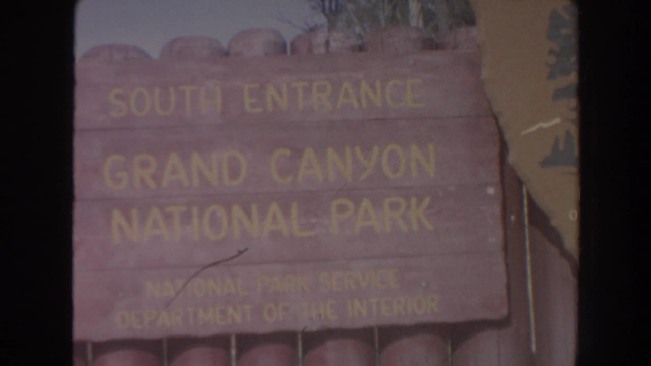 Wooden South Entrance Grand Canyon National Park sign fills the frame.