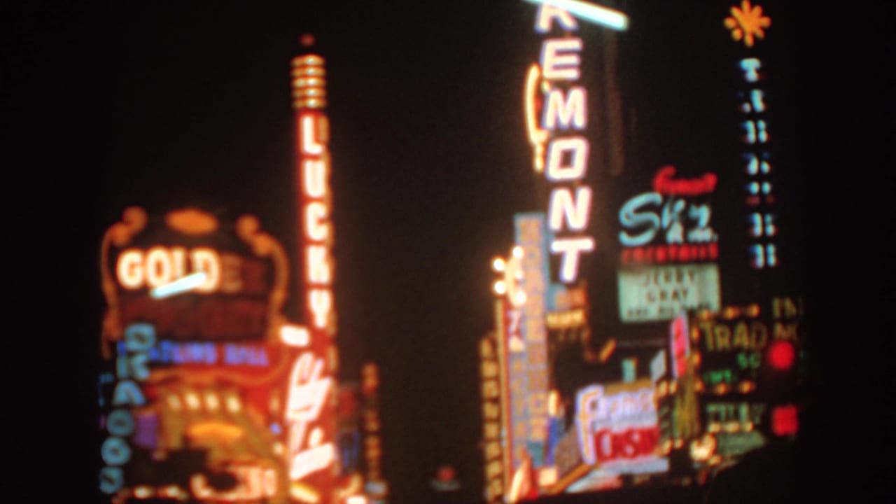 1962 8mm home-movie frame showing Las Vegas casino and hotel neon signs at night, with Golden Nugget and Fremont signage visible.