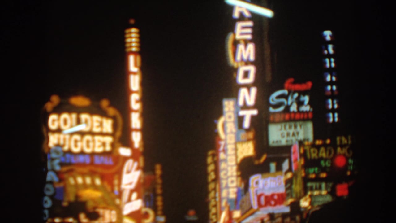 Night view of bright casino signs with Golden Nugget, Fremont, and Lucky lettering visible.