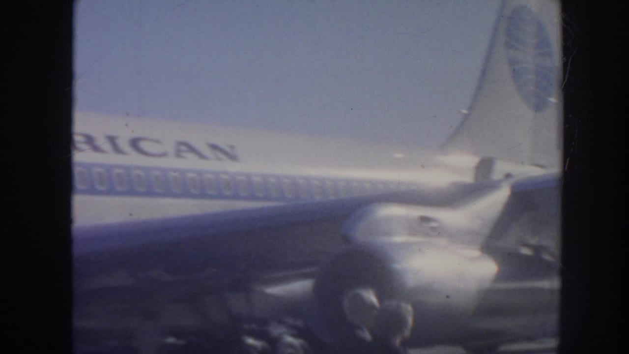 Pan American jet fuselage and tail area with engine and small figures nearby.
