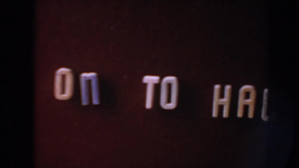 8mm home-movie title card with retro white lettering, partially visible as 'ON TO HAI' in the frame.