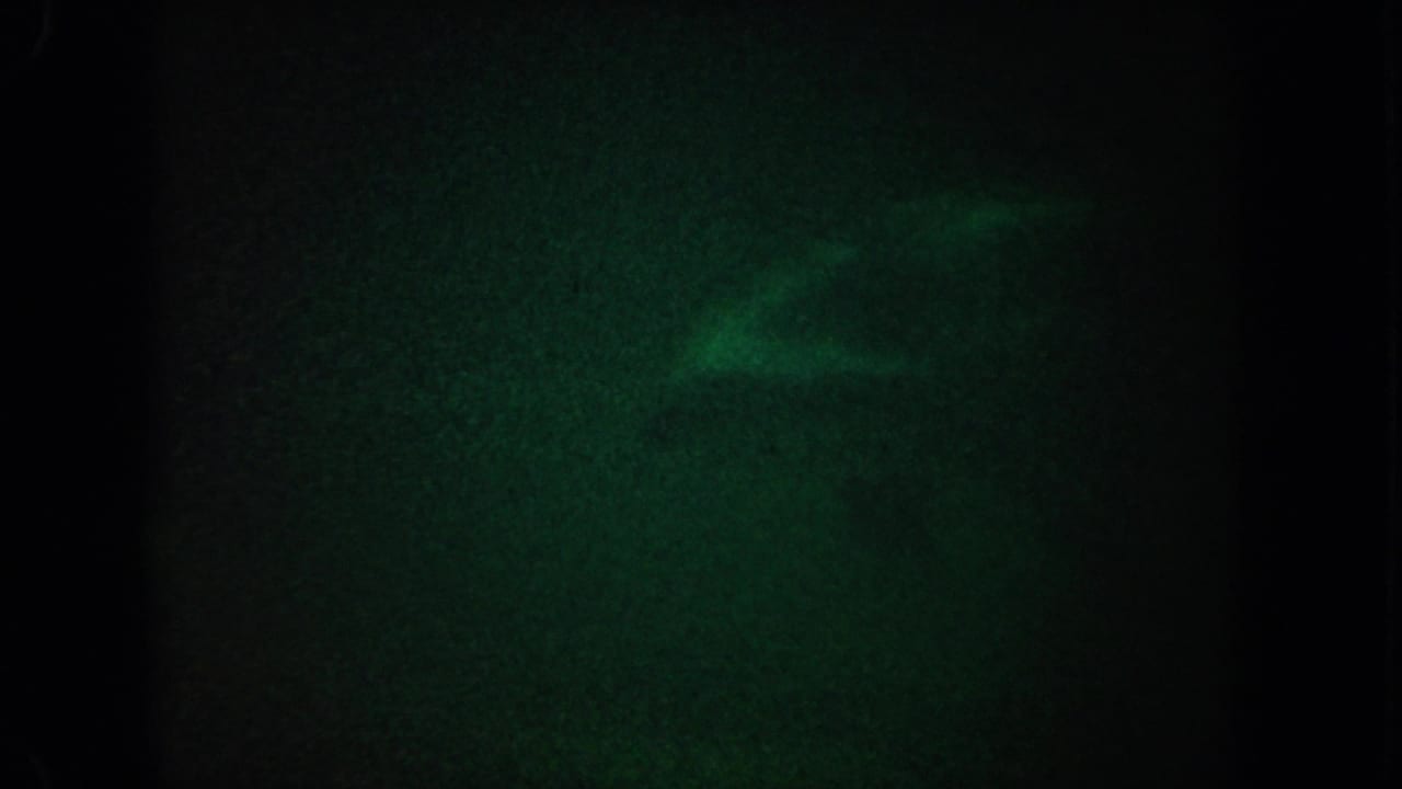 Dark green underwater frame with faint pale shapes near the upper edge.