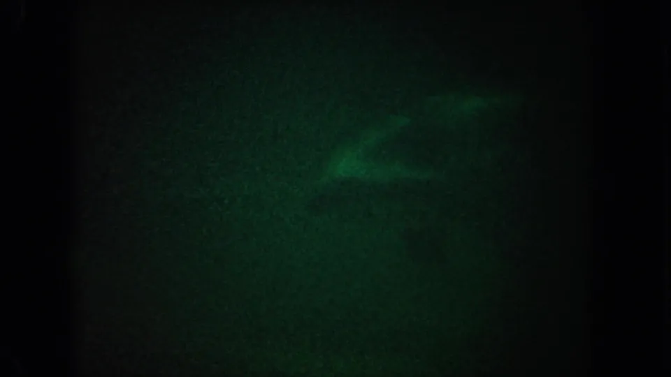 1962 California 8mm frame showing green-tinted dark water with indistinct pale underwater shapes near the top.
