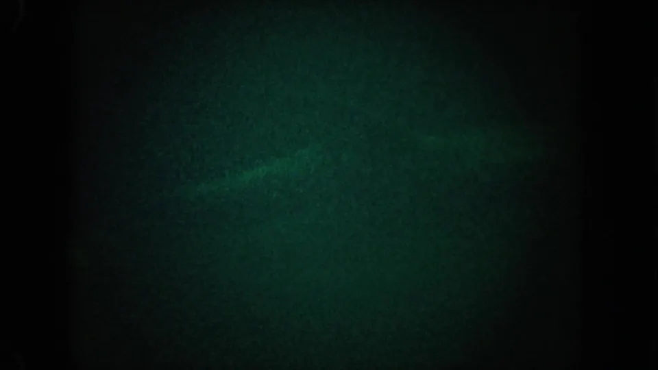 1962 California 8mm frame showing dark green water and a faint pale underwater shape near the lower center.
