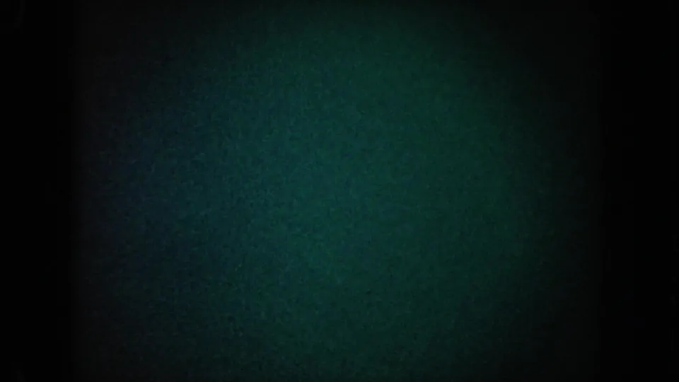 1962 California 8mm frame showing a mostly dark blue-green grain field, black side borders, and a vertical shadow through the center.