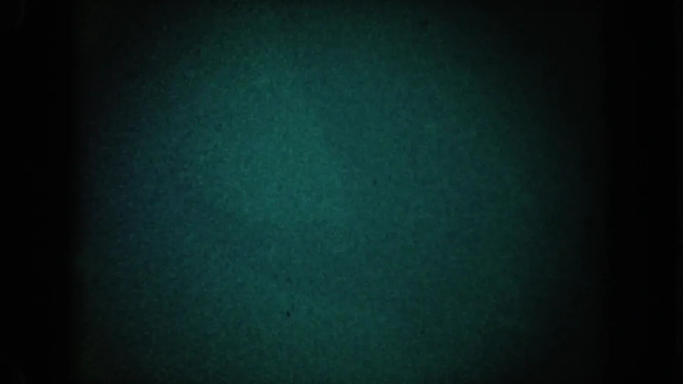 1962 California 8mm frame with a dark blue-green grain field, black edges, and slight flicker-like tonal variation.