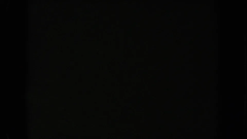 1962 California 8mm frame that is nearly black, with faint green cast, coarse grain, and edge shadows but no readable subject matter.