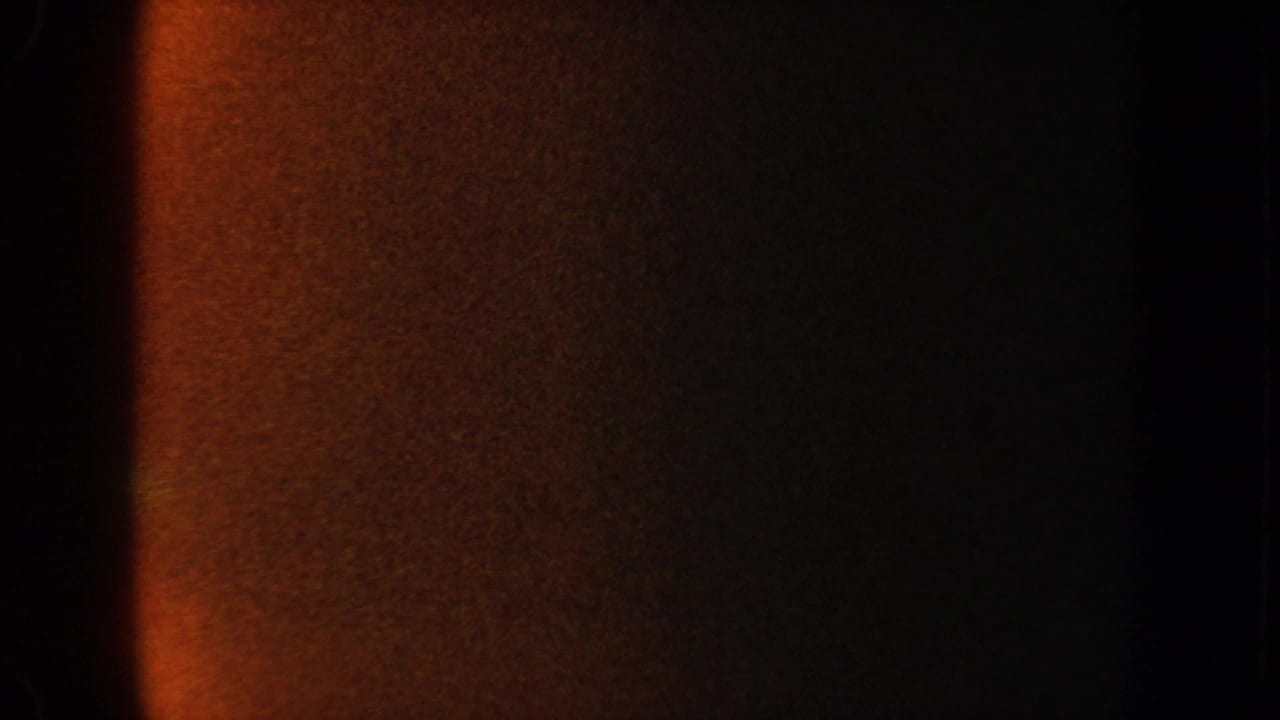 Dark orange and black film area beside a dim aquarium frame edge.