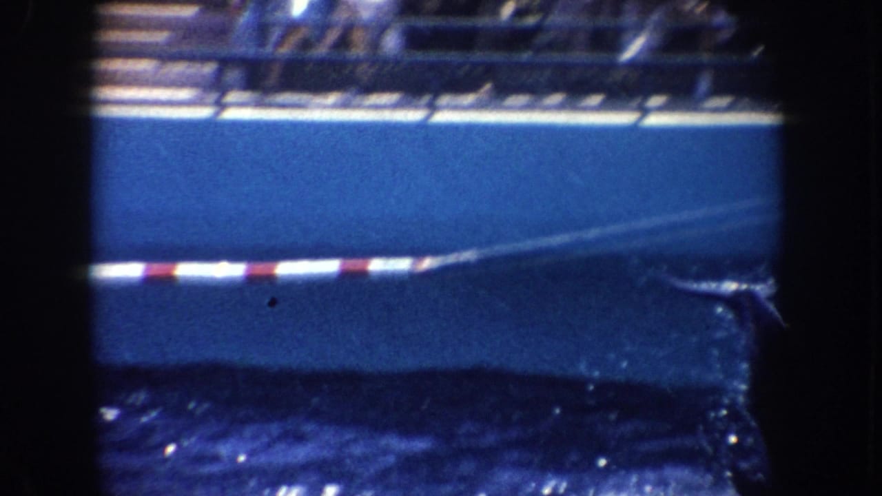 1962 California 8mm frame showing bright water, a blue edge, and a red-and-white striped line within dark film borders.