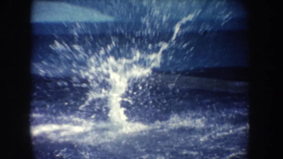 1962 California 8mm frame showing a large splash in the pool after the dolphin movement, with heavy grain and dark frame edges.