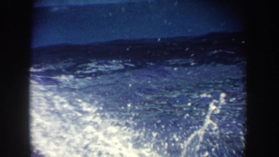 Color 8mm frame from the California boat scene showing disturbed blue water and spray after the animal's movement.