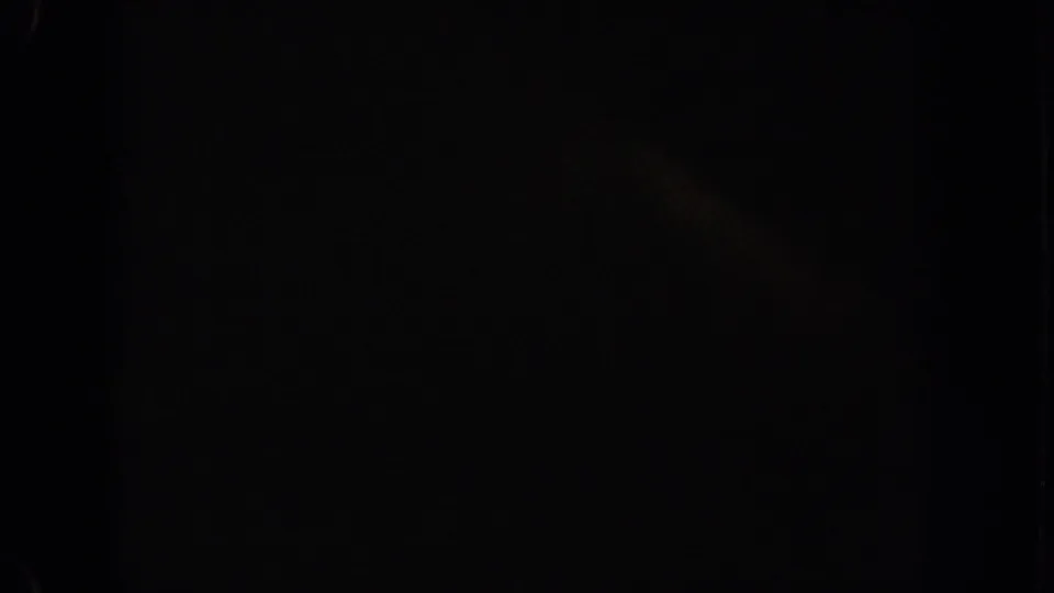Near-black 8mm frame at the end of the clip with faint color remnants and visible film darkness.