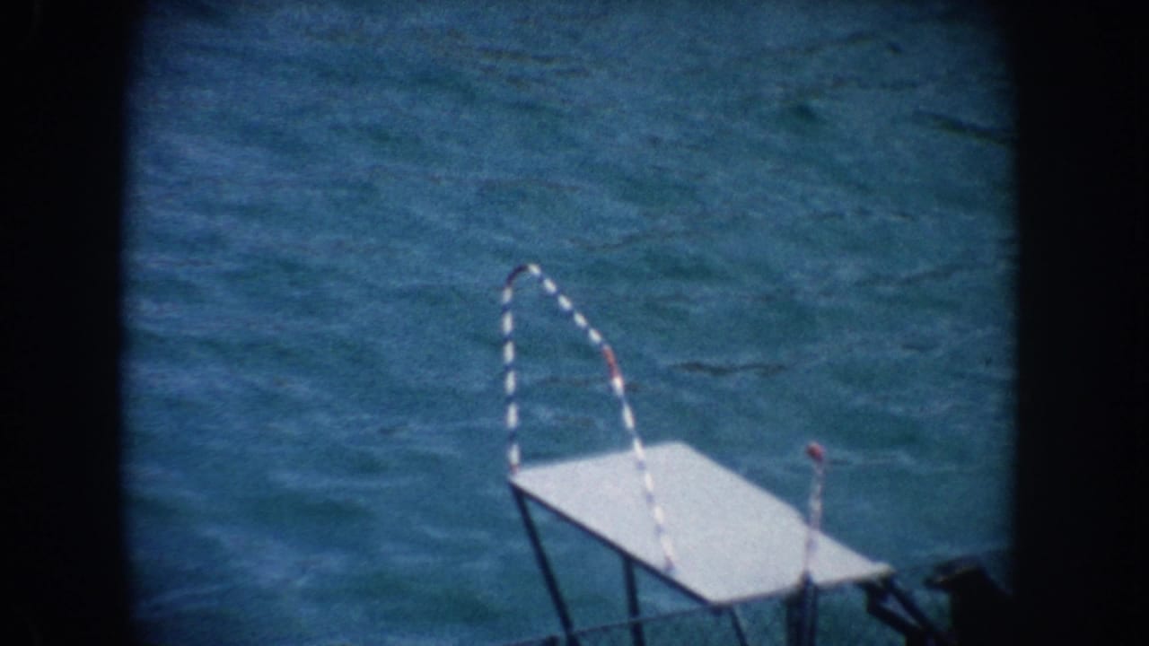 White platform with striped arched pole above blue pool water.