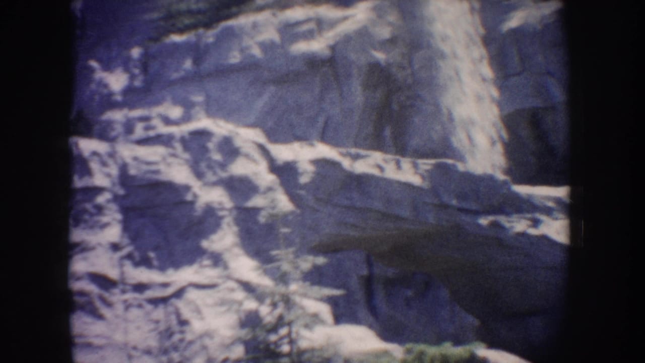 1962 Anaheim 8mm frame showing water moving over rugged rocks with a blue-purple aged-film cast.