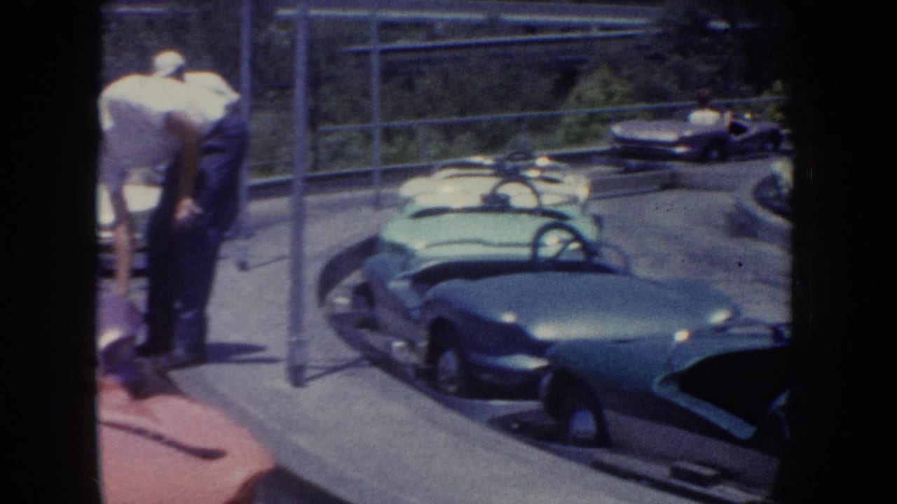 1962 Anaheim amusement-park footage showing green bumper cars on a curved track with a supervising man nearby.