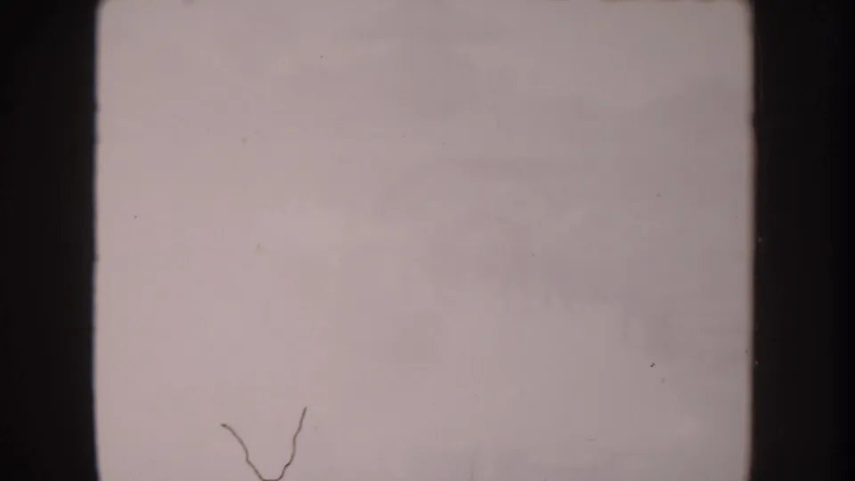 Faded 8mm frame from the 1962 Anaheim clip, largely washed out with only indistinct traces of the waterfront scene visible.