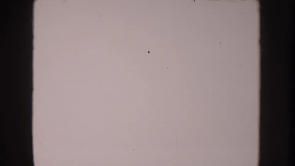 Anaheim 1962 8mm frame is nearly blank, showing pale faded emulsion, small dust marks, and dark vertical film borders.