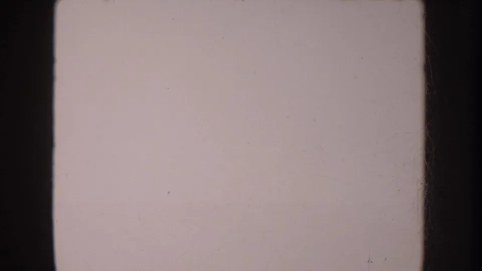 Faded 8mm frame from the 1962 Anaheim clip, showing a mostly pale overexposed area with dark film borders and dust marks.