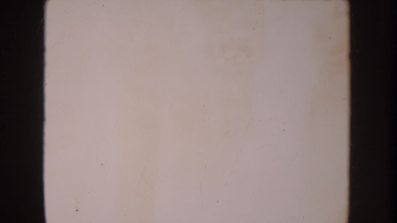 Mostly blank 8mm frame from the 1962 Anaheim clip, showing pale exposure, dark borders, and minor dust marks.