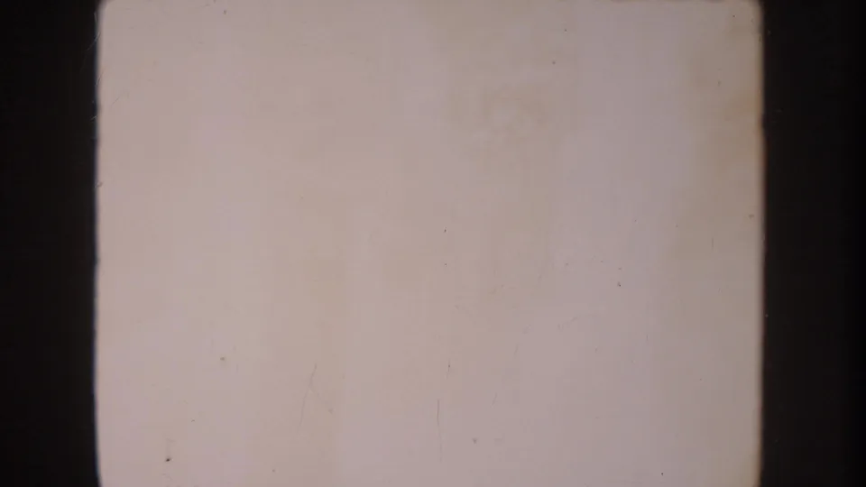 Mostly blank 8mm frame from the 1962 Anaheim clip, showing pale exposure, dark borders, and minor dust marks.