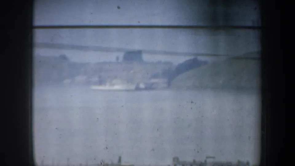 Distant water view near San Francisco, with hazy hills and shoreline structures seen through soft 8mm exposure.
