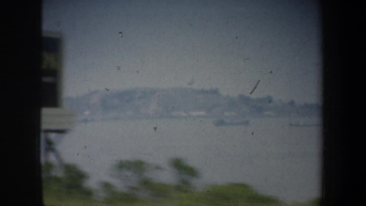 Distant shoreline across water with a vertical structure near the foreground.